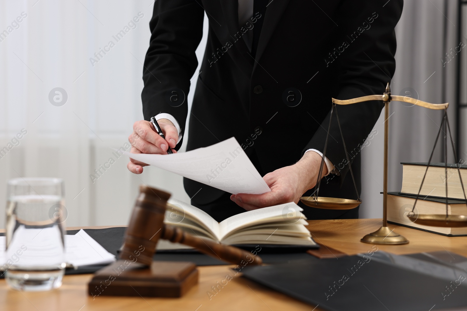 Photo of Lawyer working with document at wooden table, closeup