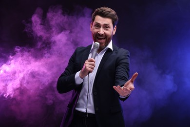 Photo of Emotional man with microphone singing in neon lights