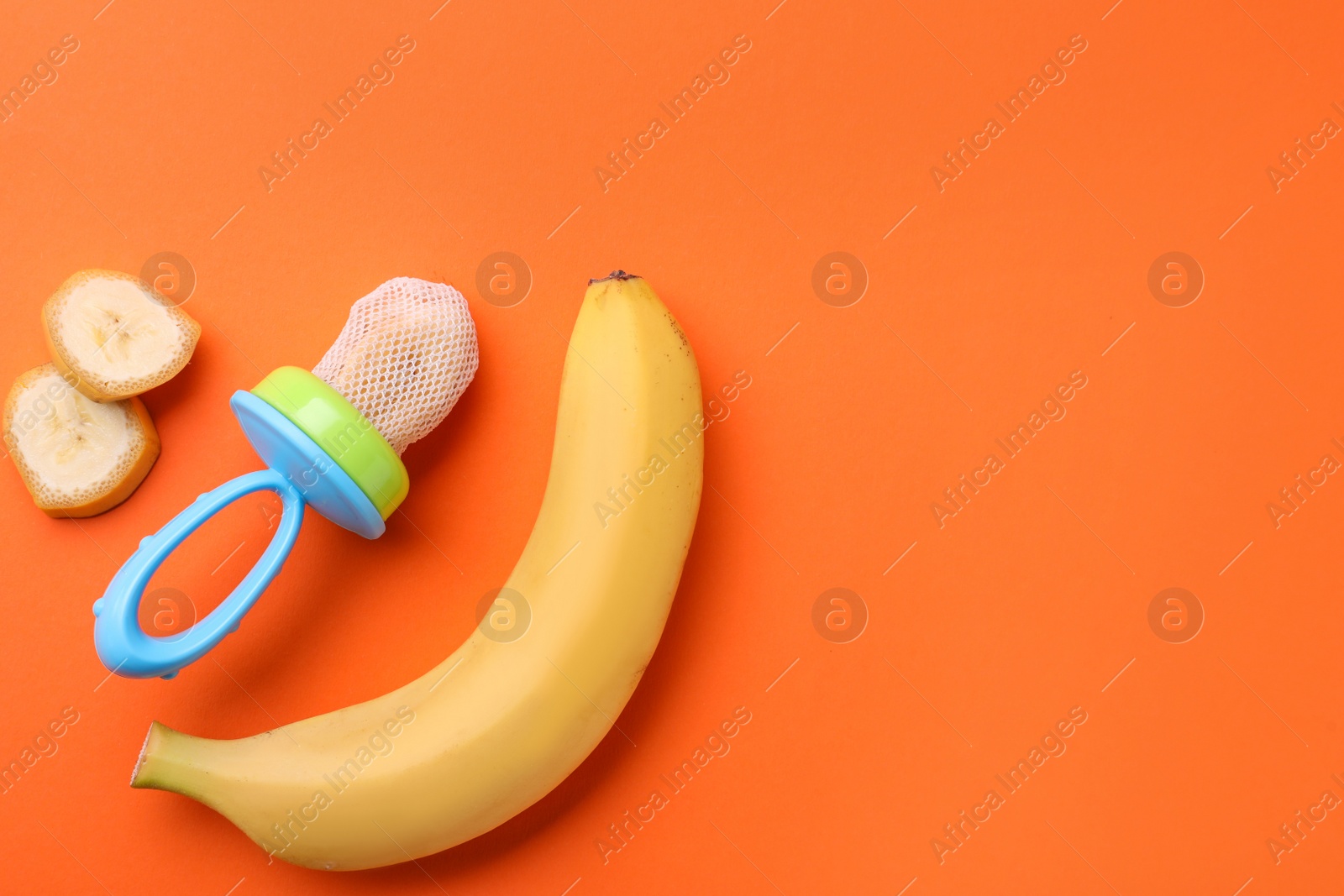 Photo of Nibbler with fresh banana on orange background, flat lay. Space for text