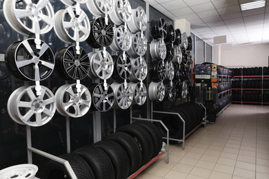 Image of Car tires and alloy wheels on rack in auto store