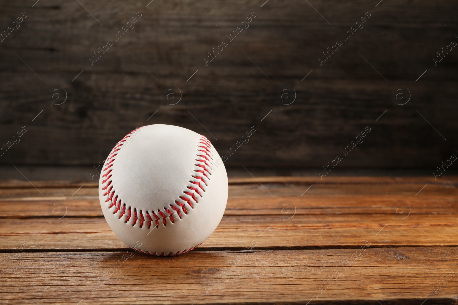 Photo of Baseball ball on wooden background, space for text