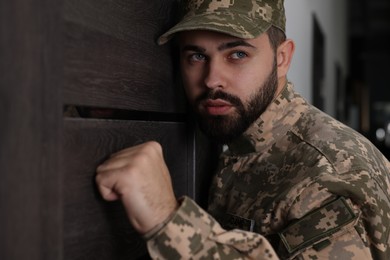 Photo of Military commissariat representative knocking on wooden door