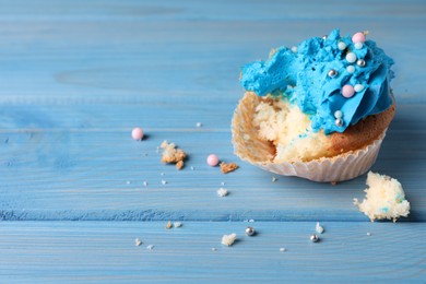 Failed cupcake on blue wooden table, closeup. Troubles happen