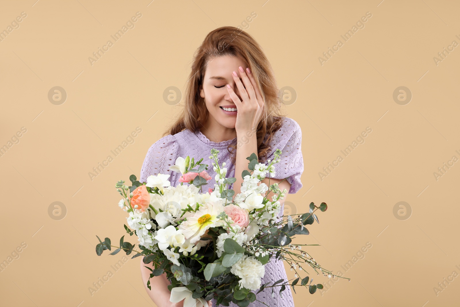 Photo of Beautiful woman with bouquet of flowers on beige background