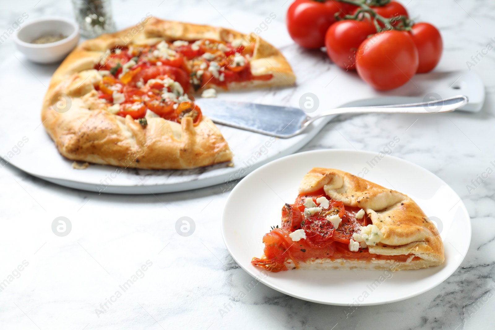 Photo of Tasty galette with tomato and cheese (Caprese galette) on white marble table, closeup