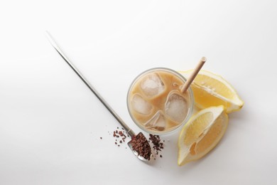 Photo of Iced coffee with milk in glass, cut lemon and instant coffee on white background