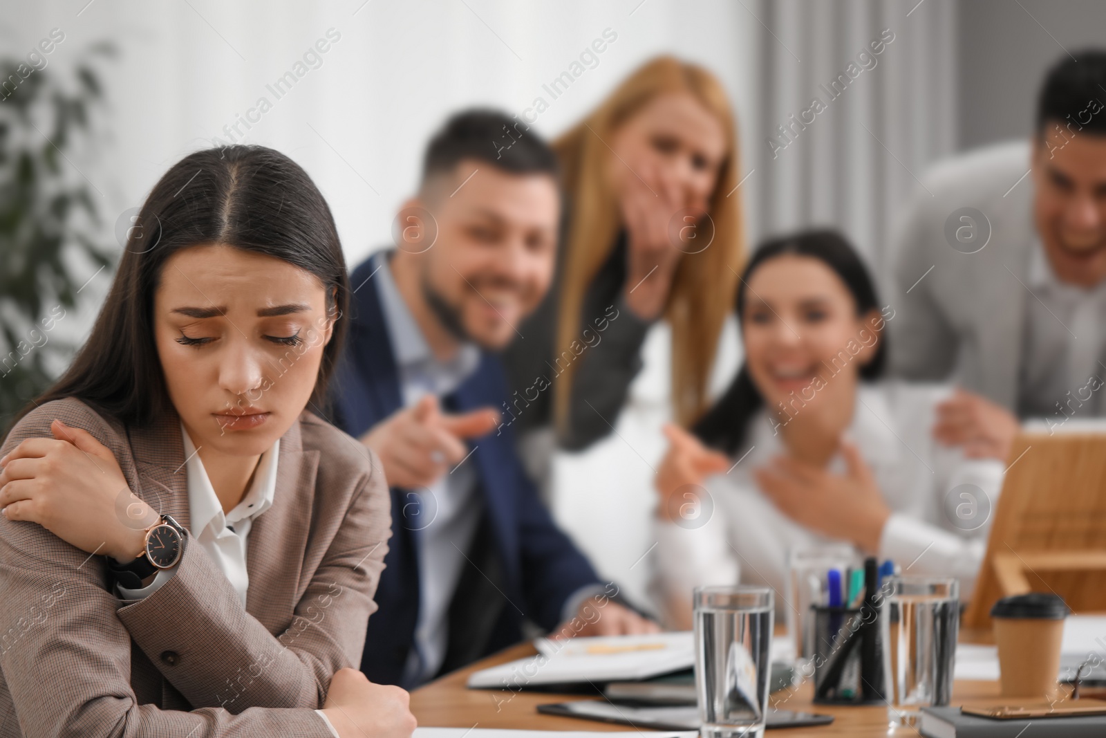 Photo of Coworkers bullying their colleague at workplace in office