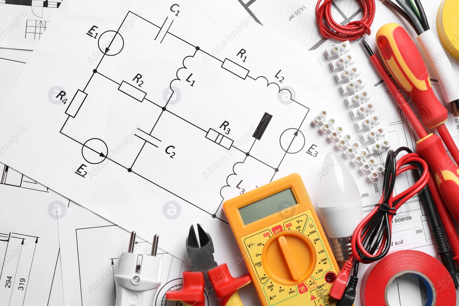 Photo of Set of electrician's tools and accessories on paper sheets with scheme, flat lay