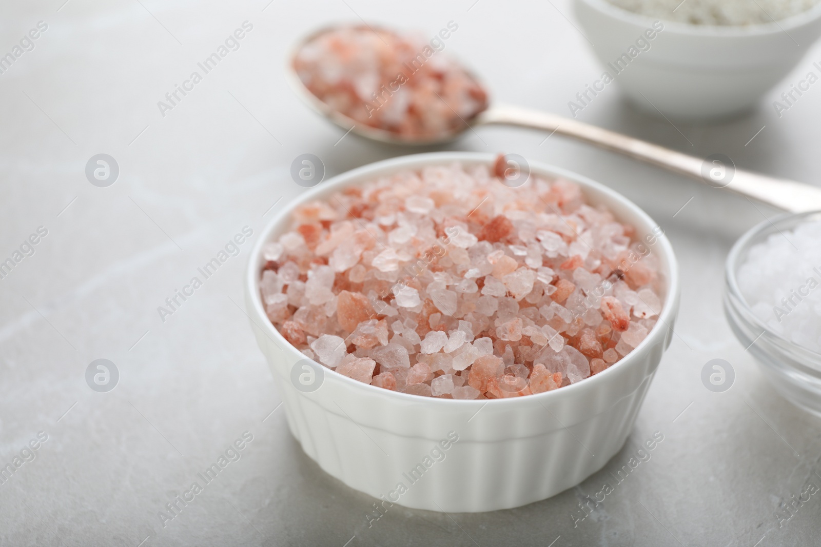 Photo of Pink Himalayan salt in bowl on light grey table