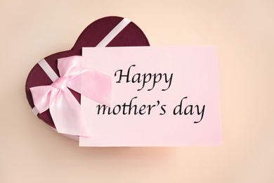 Photo of Gift box and card with words "Happy Mother's Day" on light background, top view