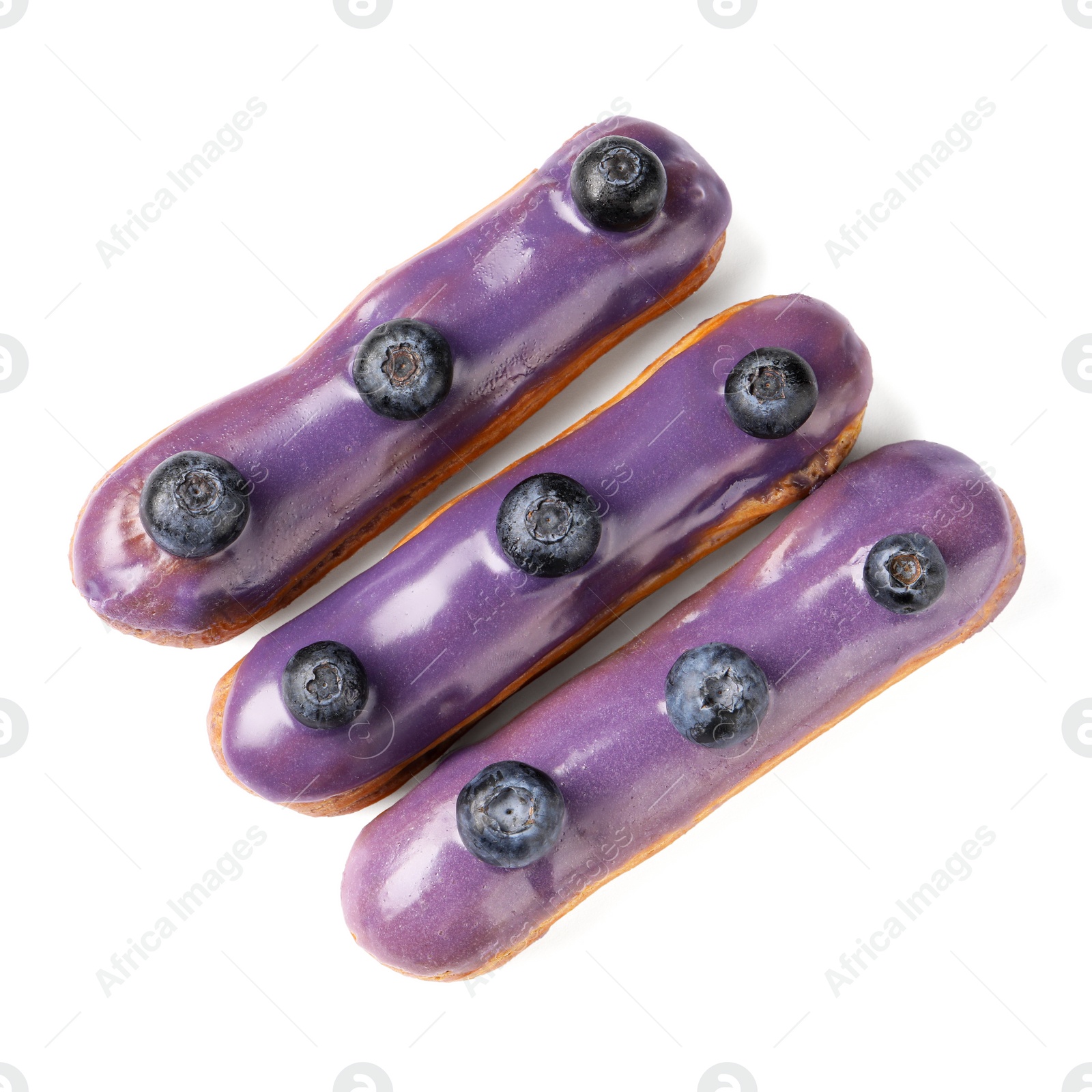 Photo of Delicious eclairs decorated with blueberries isolated on white, top view