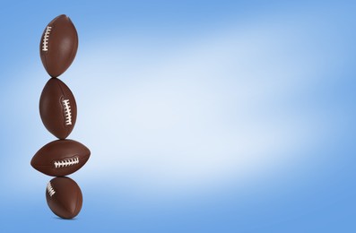 Image of Stack of rugby balls on blue background. Space for text