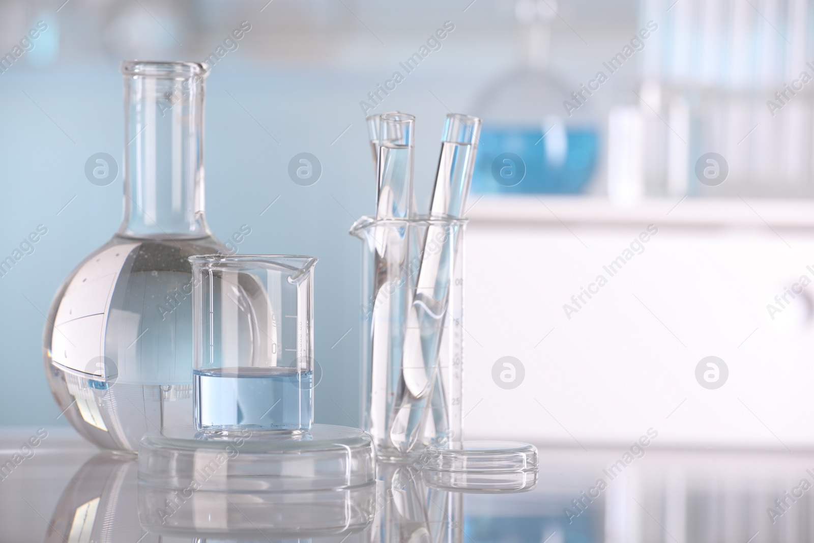 Photo of Laboratory analysis. Different glassware with liquid on white table indoors, space for text