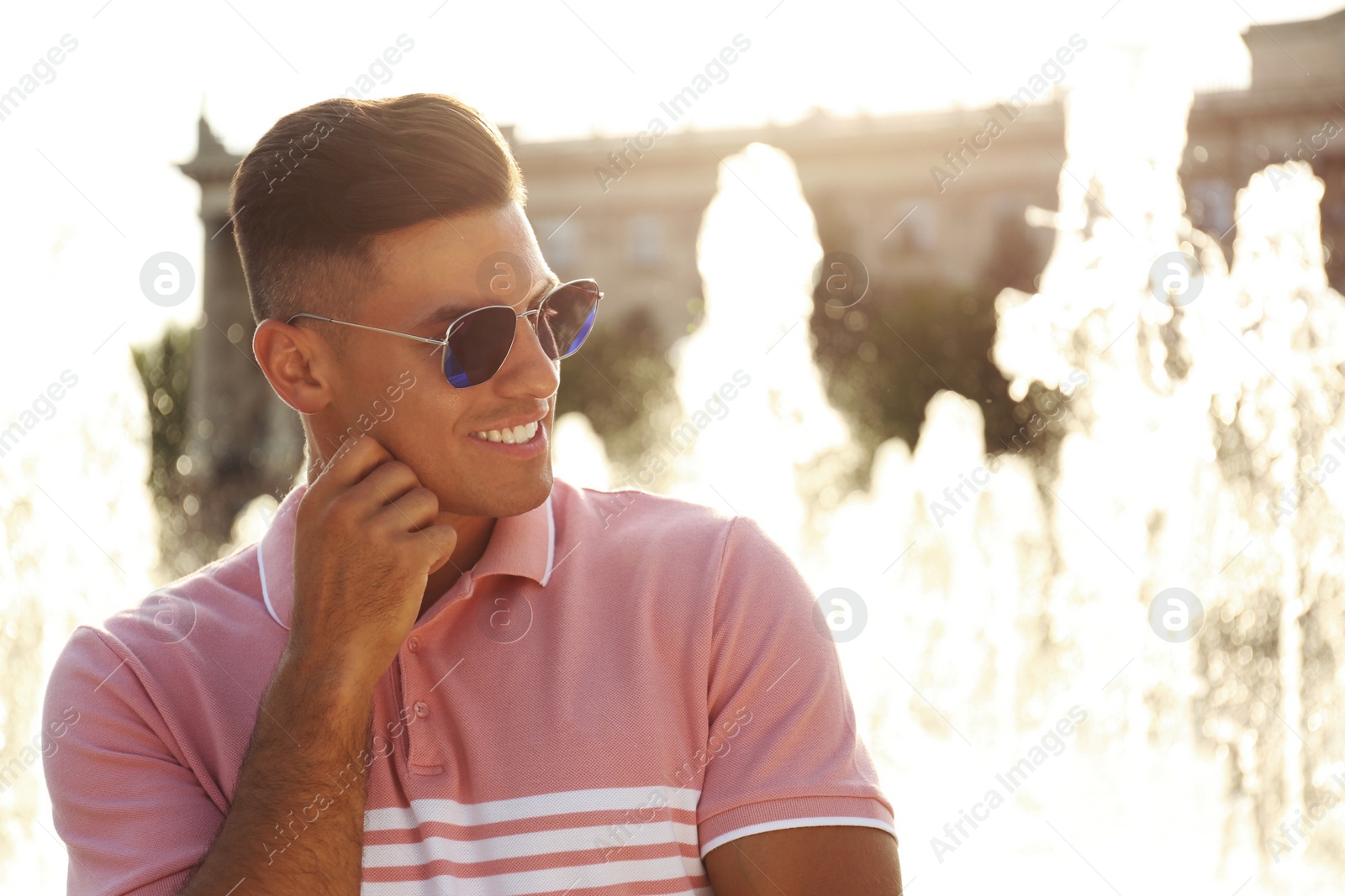 Photo of Handsome man wearing stylish sunglasses on city street. Space for text