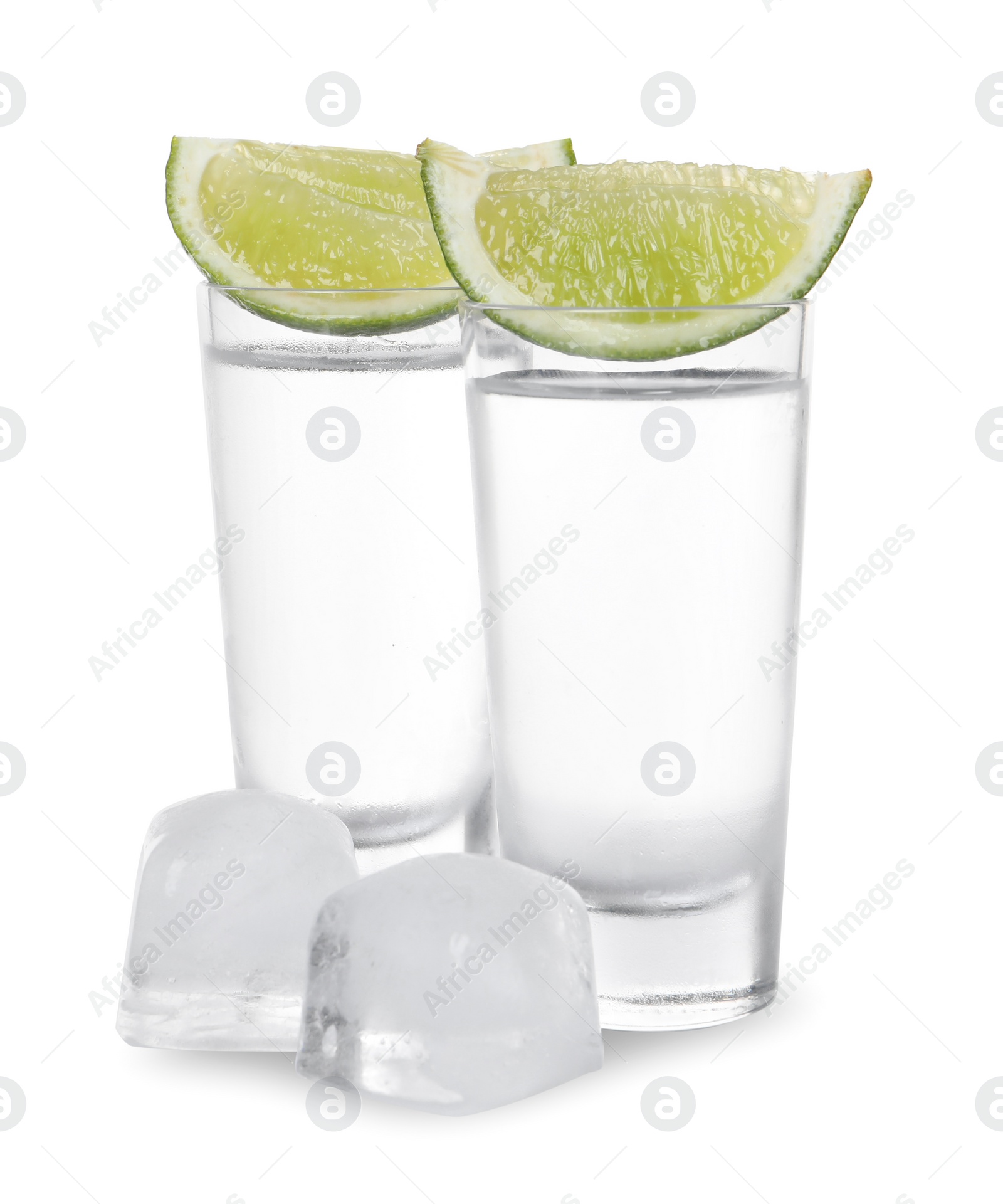 Photo of Shot glasses of vodka with lime slices and ice on white background