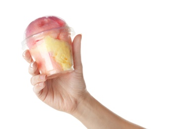 Woman holding plastic cup with yummy cotton candy on white background, closeup