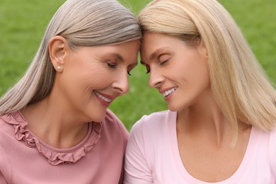 Happy mature mother and her daughter outdoors