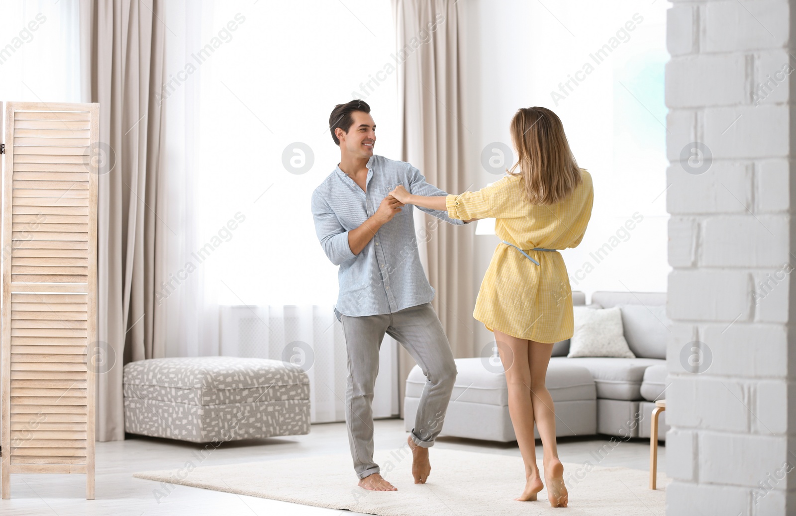 Photo of Beautiful young couple dancing in living at home