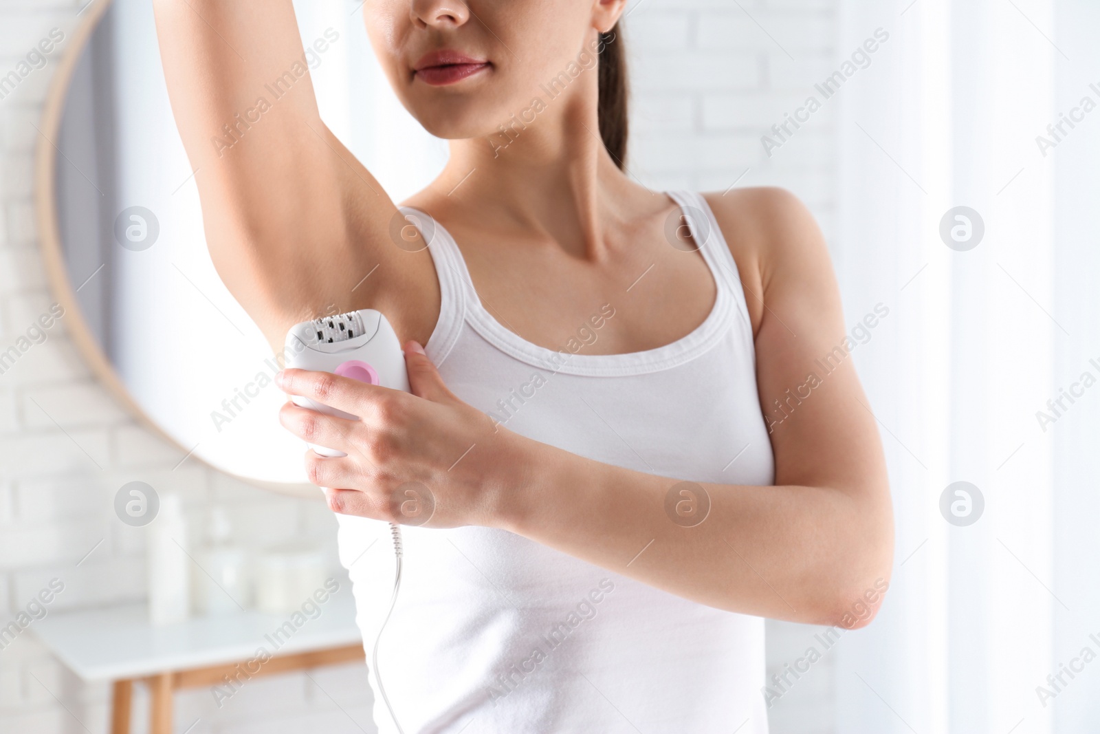 Photo of Woman doing armpit epilation procedure indoors, closeup