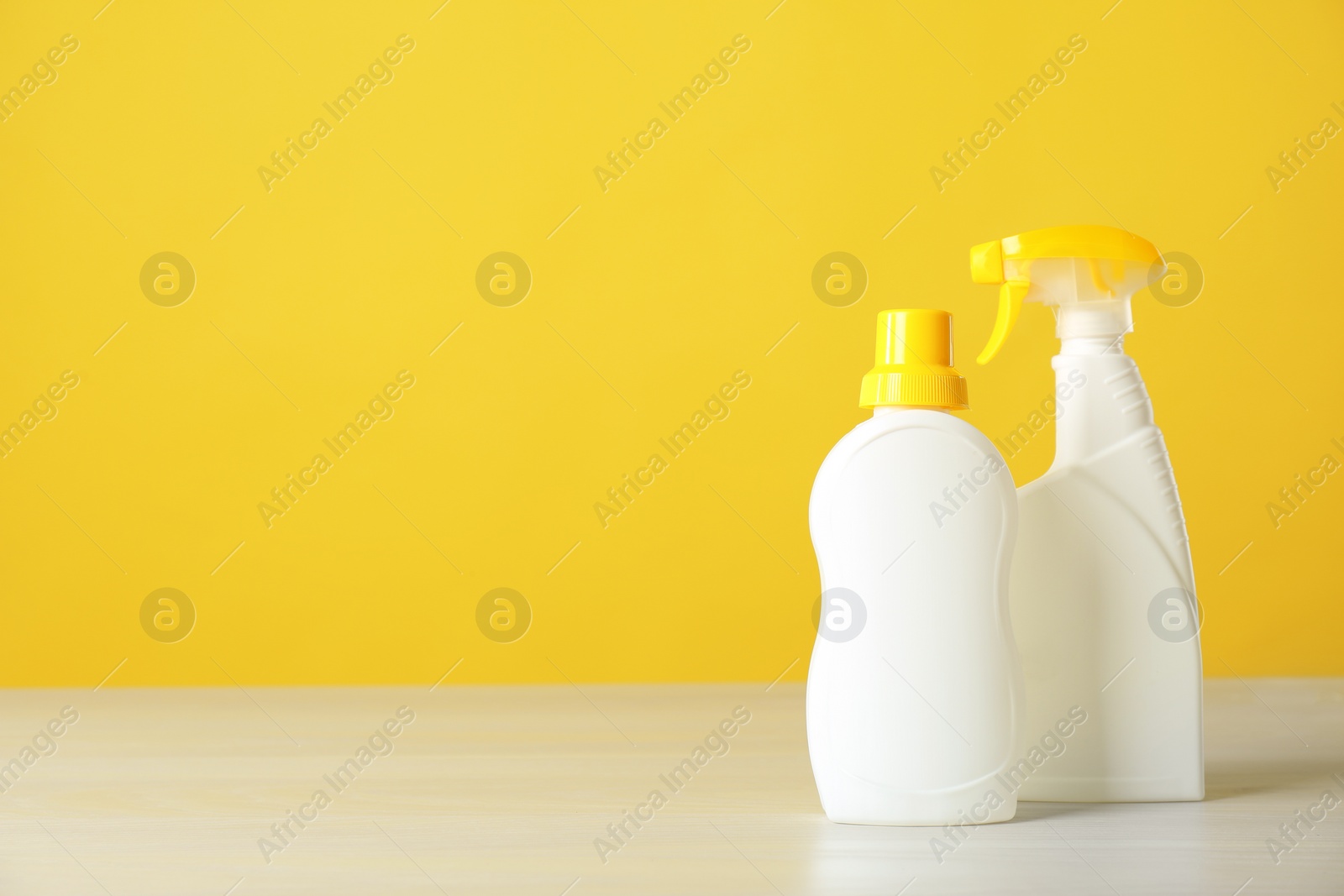 Photo of Bottles of cleaning products on light table. Space for text