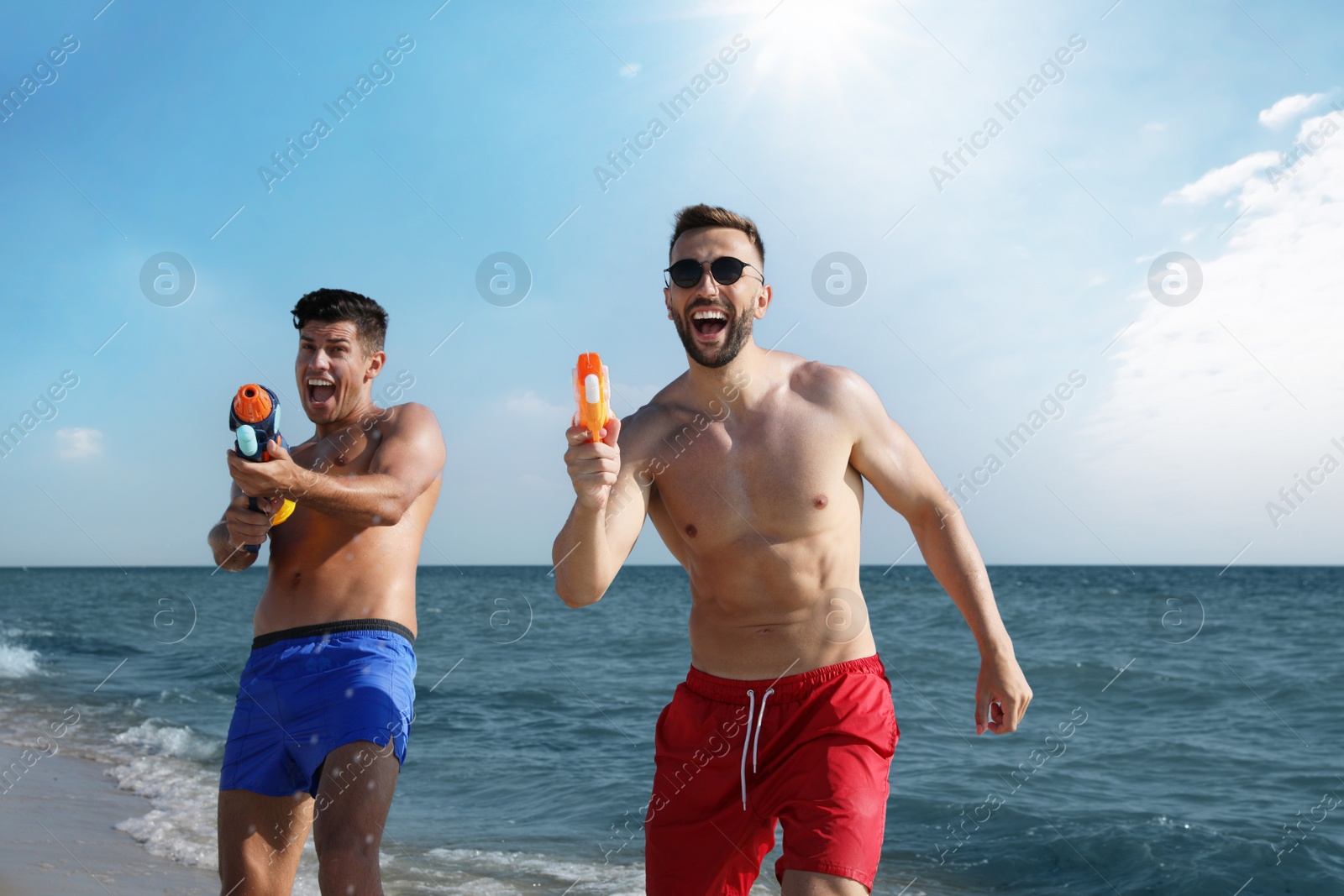 Photo of Friends with water guns having fun on beach