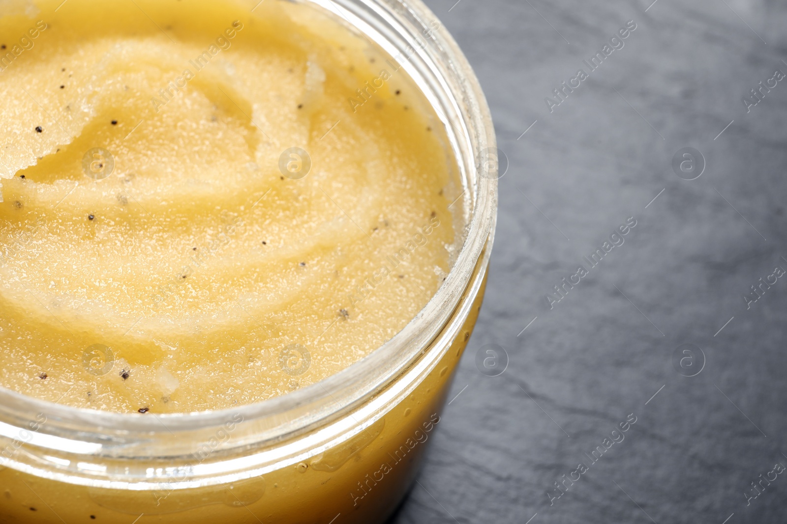 Photo of Body scrub in jar on dark table, closeup. Space for text