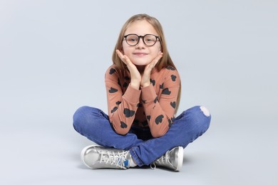 Photo of Cute girl in glasses on light grey background