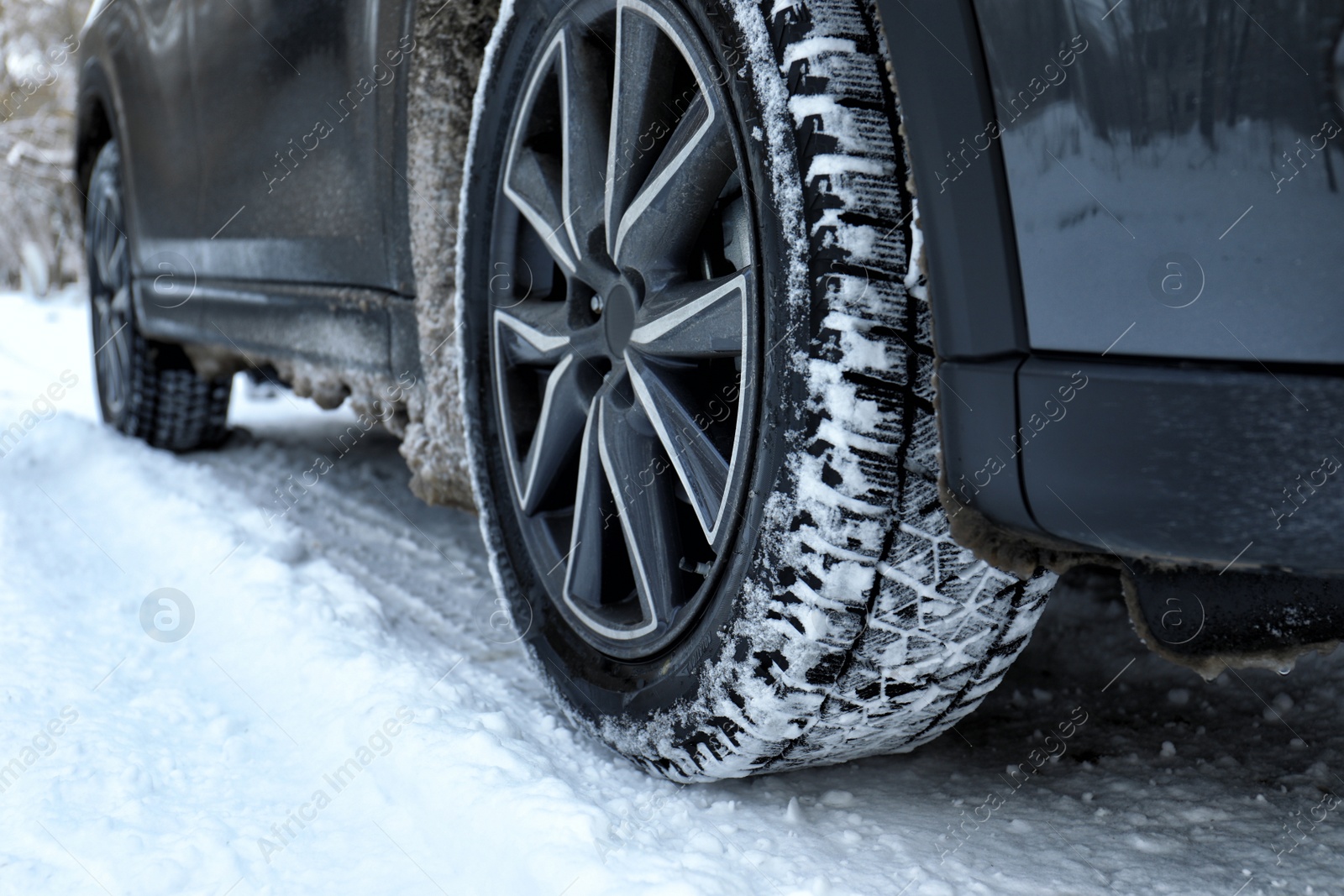 Photo of Snowy country road with car on winter day, closeup