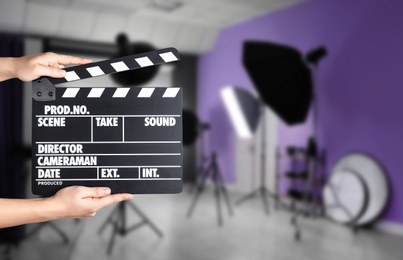 Assistant holding clapperboard on filming location, closeup. Cinema production 