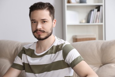 Photo of Handsome man sitting on sofa in cozy room