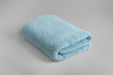 Photo of Fresh fluffy folded towel on grey background