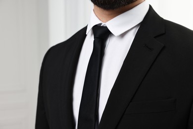 Businessman in suit and necktie indoors, closeup