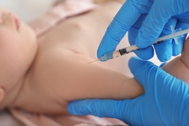 Photo of Doctor vaccinating baby in clinic, closeup