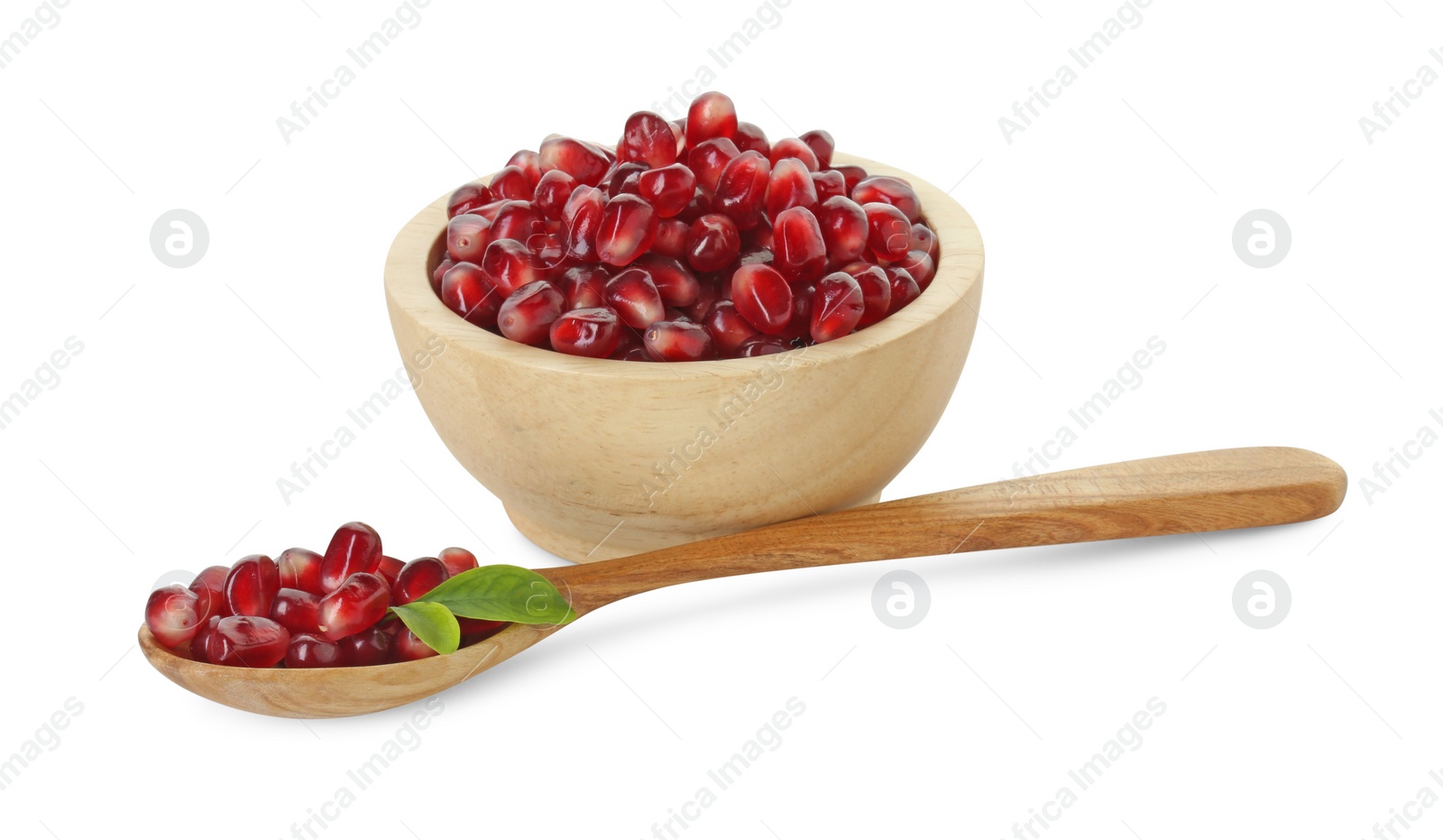 Photo of Ripe juicy pomegranate grains, leaves in bowl and wooden spoon isolated on white