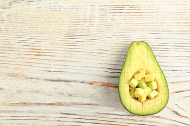 Cut avocado on wooden background, top view