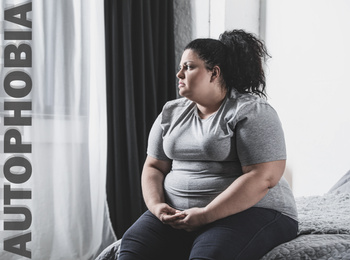 Image of Depressed overweight woman sitting alone on bed at home. Autophobia - fear of isolation
