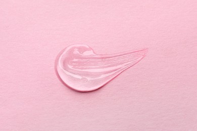 Sample of transparent gel on pink background, top view