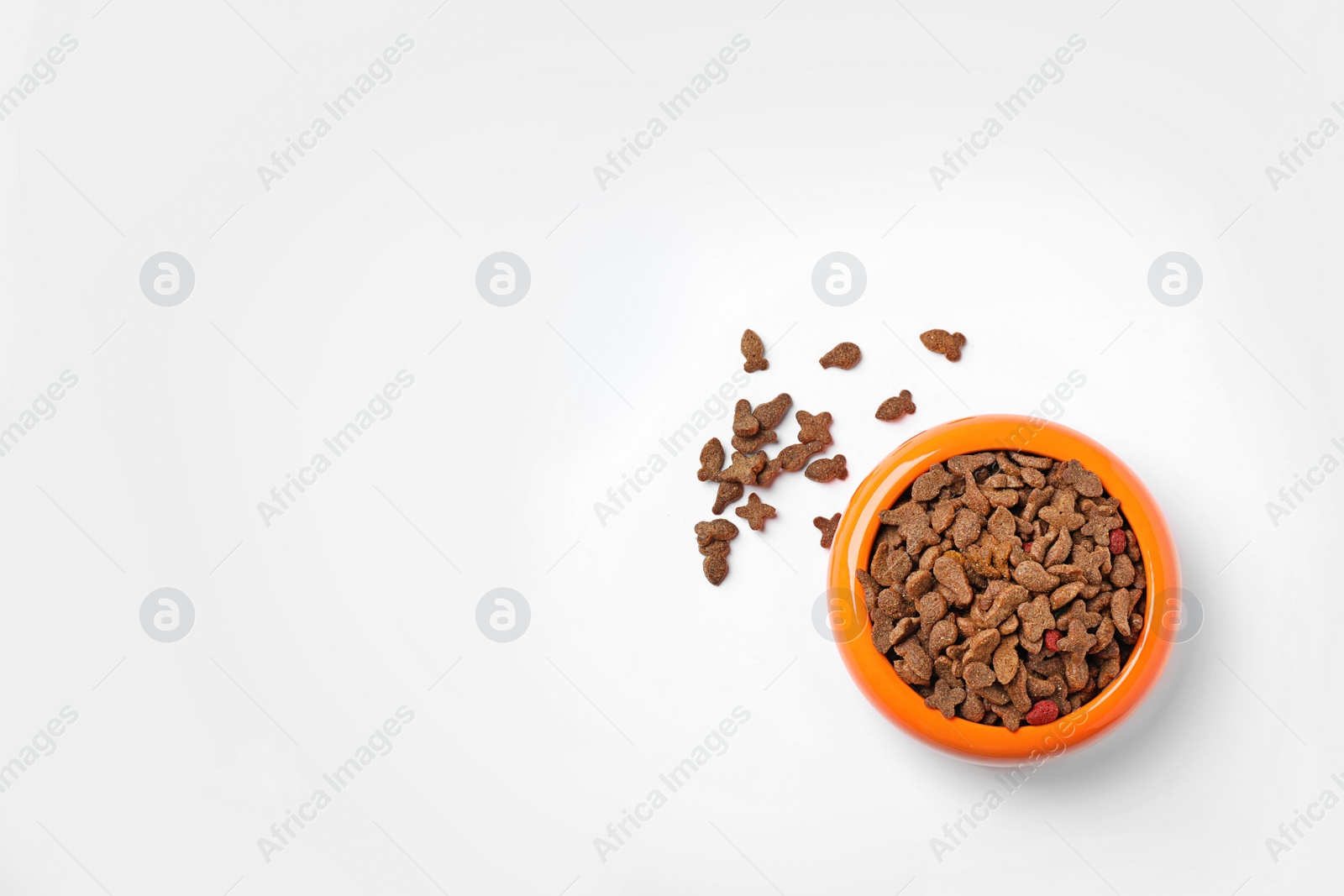 Photo of Bowl of dry pet food on white background, top view