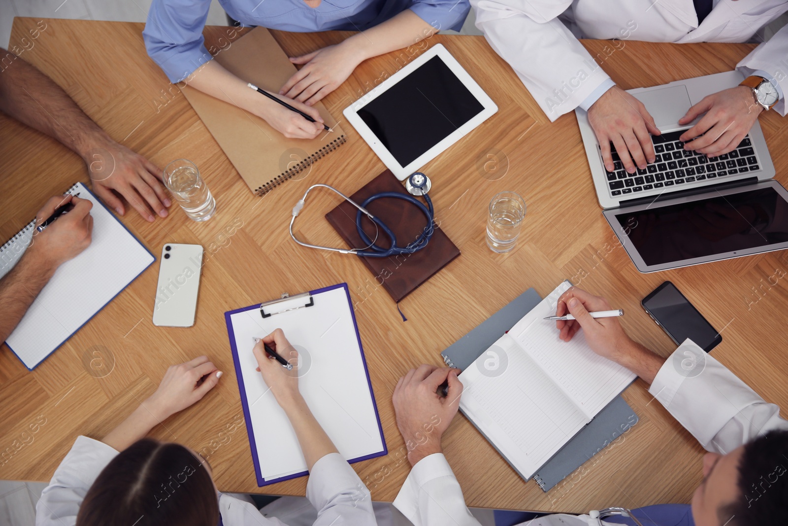 Photo of Team of professional doctors having meeting at table, top view