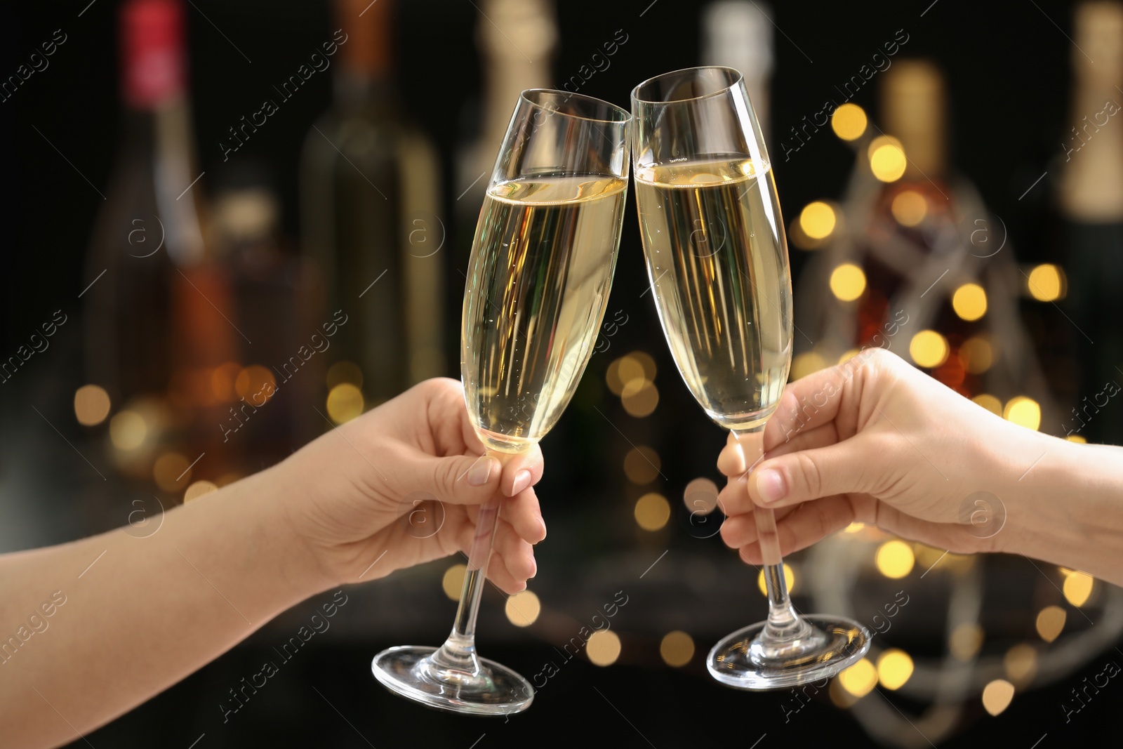 Photo of People clinking glasses of champagne on blurred background, closeup