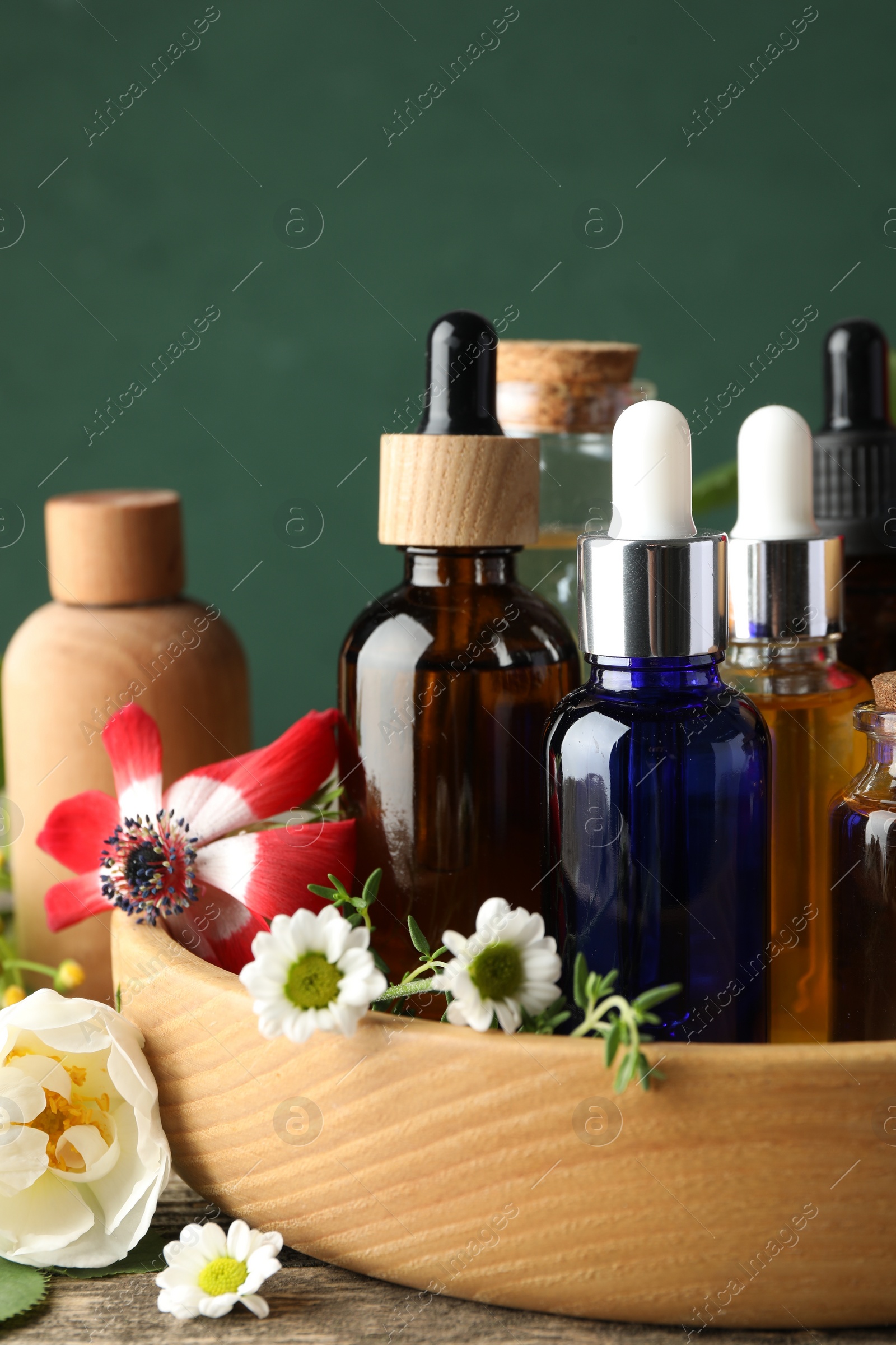 Photo of Aromatherapy. Different essential oils and flowers on wooden table