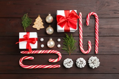 Flat lay composition with candy canes and Christmas decor on wooden table