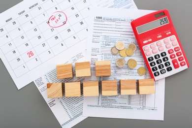 Photo of Flat lay composition with documents, calculator and wooden cubes on table. Tax day