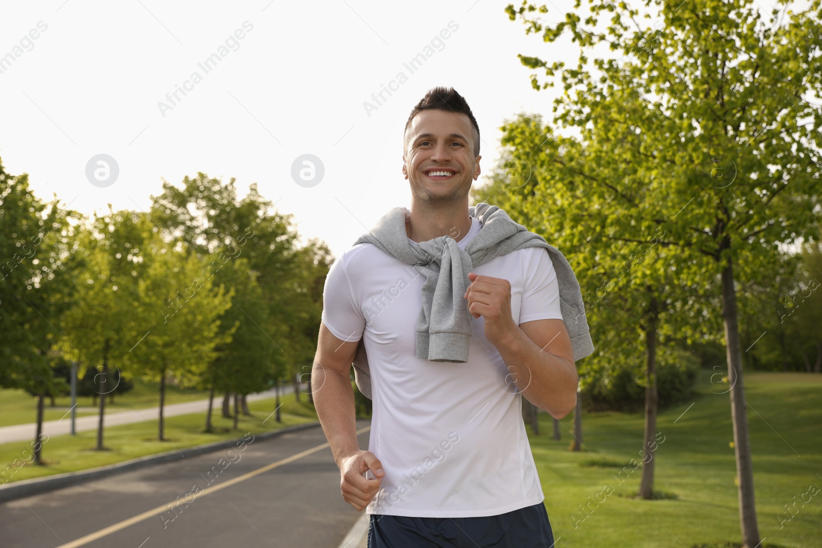 Photo of Young man in fitness clothes running outdoors