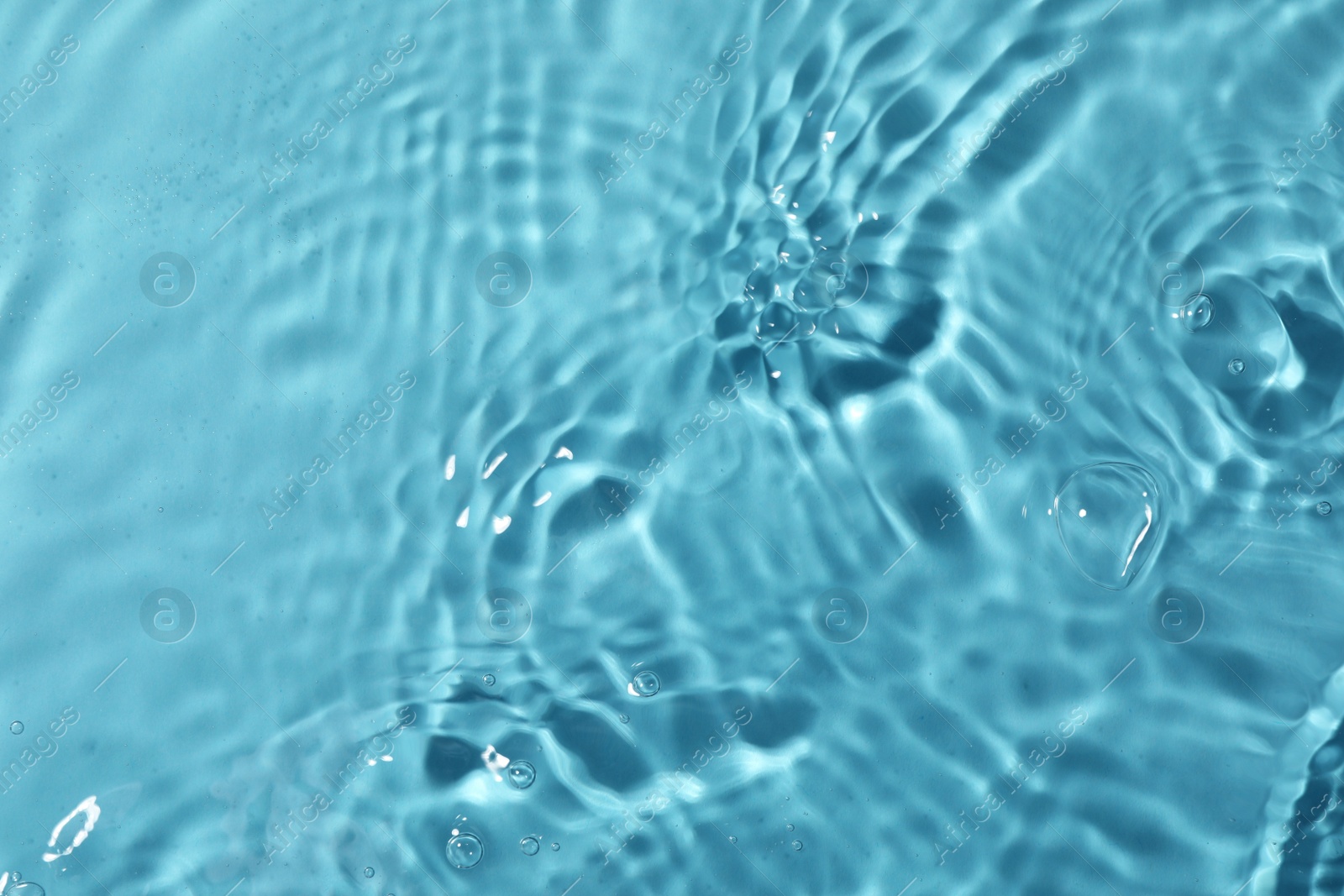 Photo of Closeup view of water with rippled surface on light blue background