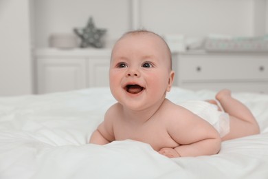Photo of Cute baby lying on white bed at home
