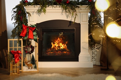 Photo of Beautiful Christmas lanterns near fireplace in room with festive decor