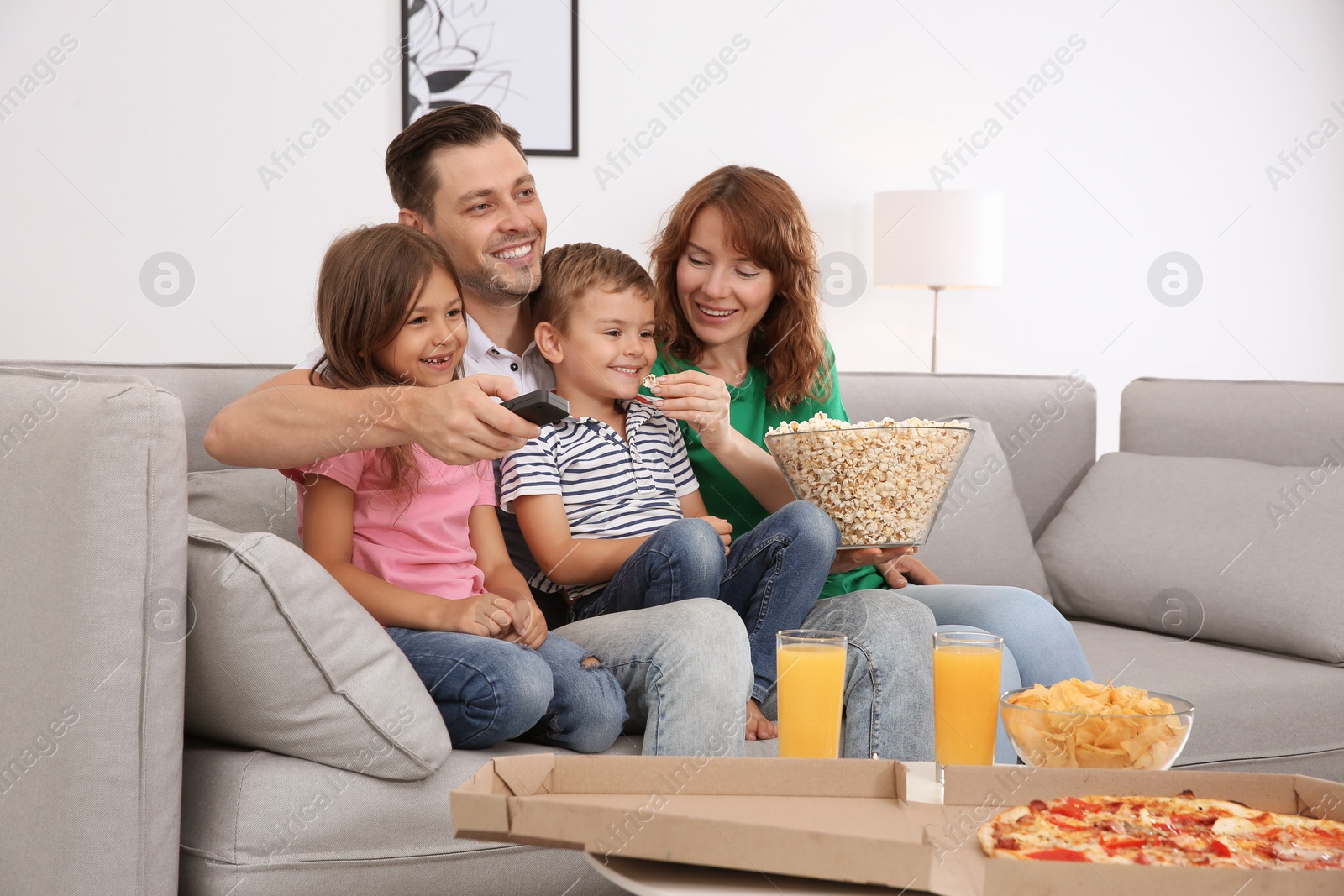 Photo of Family watching TV with popcorn in room