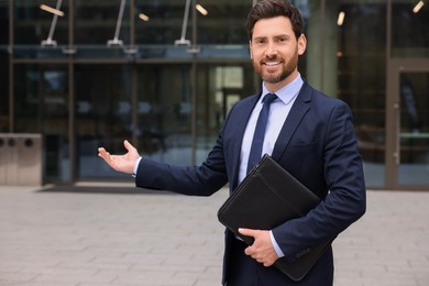 Photo of Male real estate agent with leather portfolio outdoors