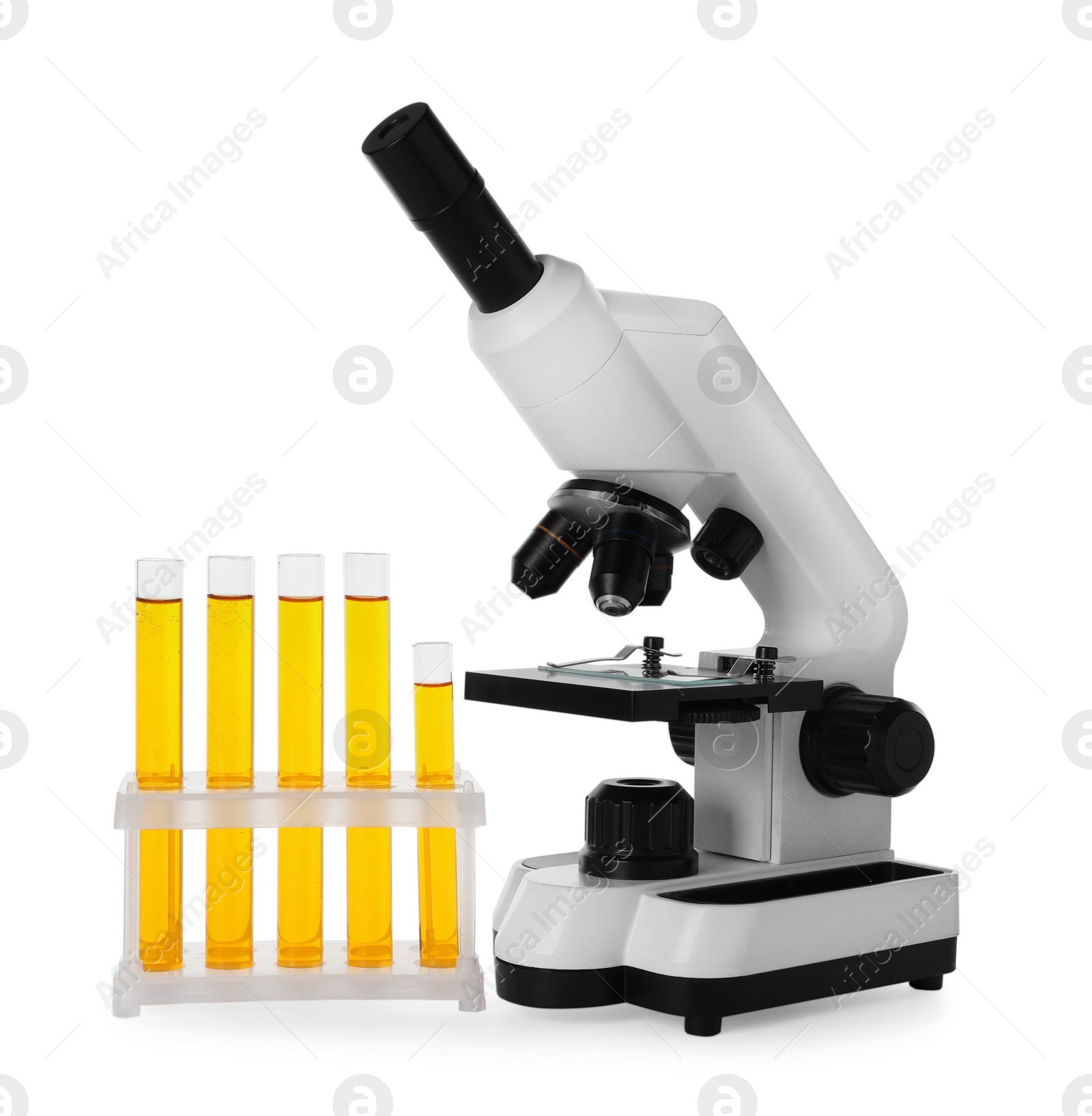 Photo of Test tubes with orange liquid and microscope isolated on white